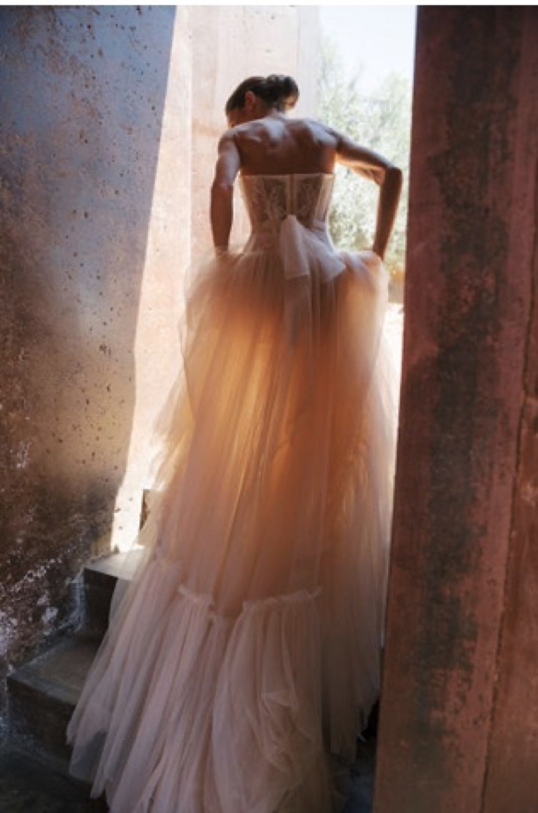 Bride's tulle gown on sunlit terracotta steps at Natalie and Kyle's wedding
